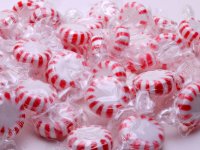 22934319-a-handful-of-red-and-white-stripe-peppermints-are-laying-on-a-white-background.jpg